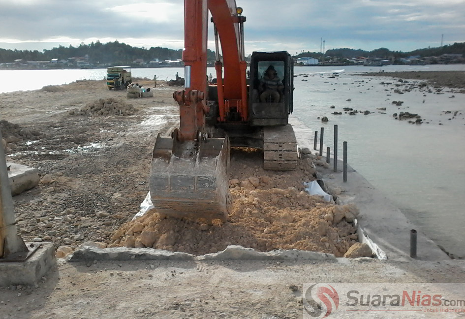 Sebuah excavator terlihat sedang beroperasi di lokasi pembangunan tempat bersandar ikat ( dermaga) di TPI Telukdalam Pasir Putih/Foto: Edi Zebua
