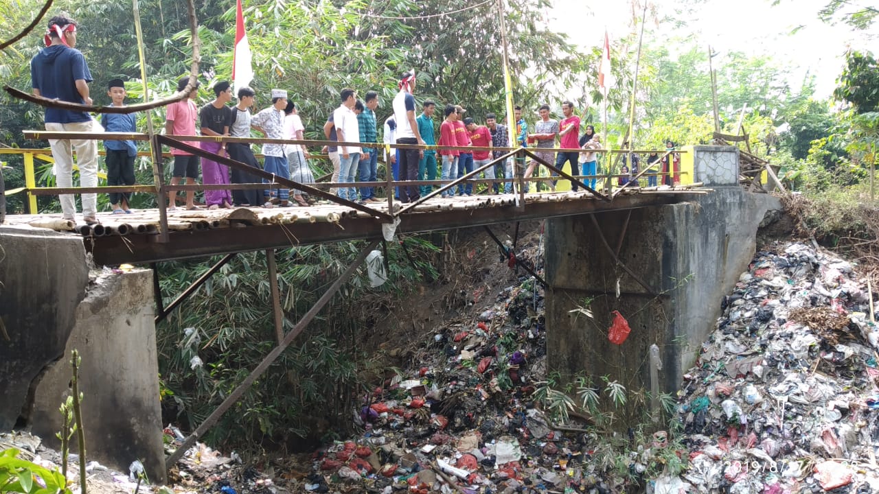 Upacara pengibaran bendera 17 Agustus 2019 yang digelar pemuda di Menes di sebuah jembatan bambu . Nampak, di bawahnya terdapat tumpukan sampah.(aep)