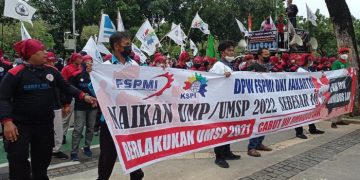 Spanduk tuntutan yang meminta Pemprov DKI menaikkan nilai UMP 2023 menjadi 10,55 persen dibentangkan didepan Balaikota DKI Jakarta . Buruh mengklaim angka kenaikkan tersebut sesuai dengan tingkat pertumbuhan ekonomi di Indonesia.