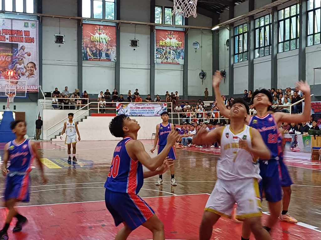 Diapit : Seorang Pemain Tim Basket Putra Kota Tangerang (Putih) diapit oleh Dua Pemain Tim Basket Kota Serang pada Ajang POPDA XI Banten di Gor Damyati Kota Tangerang