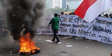 Massa aksi 'Indonesia Gelap' mulai berkumpul dan membakar ban di kawasan Patung Kuda, Jakarta Pusat, Kamis (20/02/2025). (Ilham F/Suaranusantara).