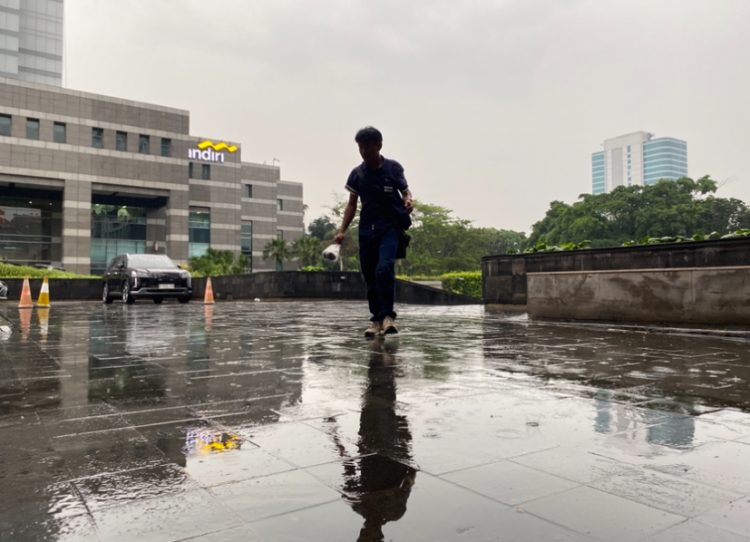 Seorang pria sedang bejalan dalam kondisi hujan (Dok Fifi/Suaranusantara.com).