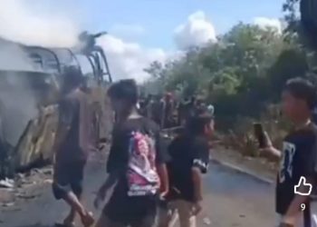 Warga sekitar menyaksikan bangkai bus ALS yang terlibat kecelakaan maut dengan Truk tangki BBM di Muratara, Sumatera Selatan (YouTube @Radioelshinta)
